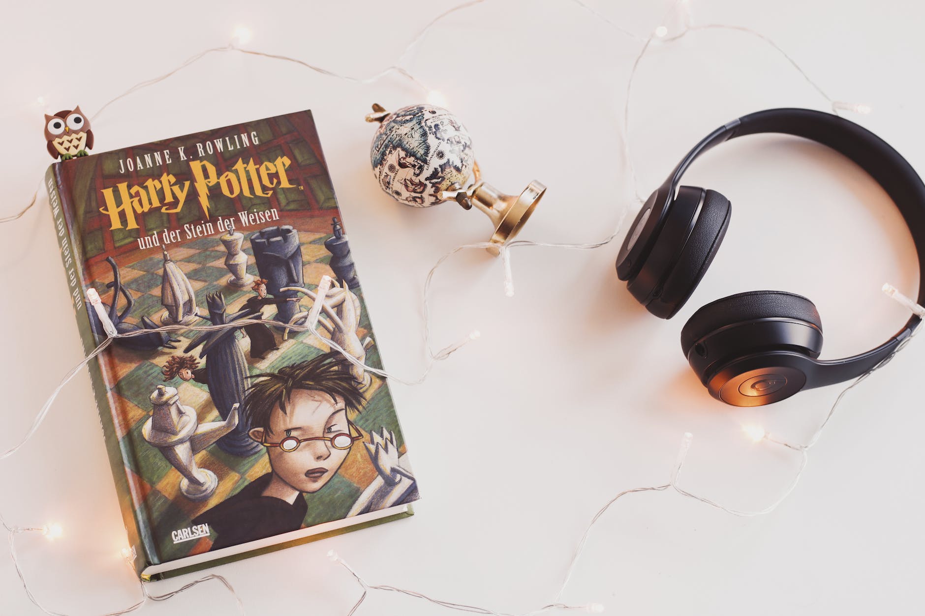 harry potter book and black headphones with trinket